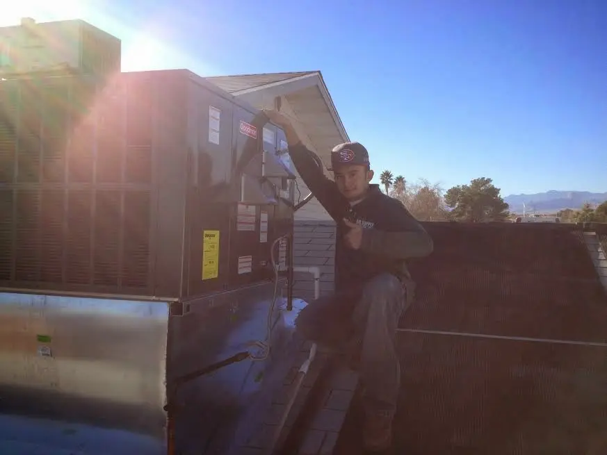 HVAC technician performing AC Tune-Up on a rooftop unit in Morrow